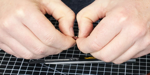 Replier les bords du cuir à l'intérieur du bouton pression